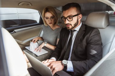 yakışıklı işadamı araba, defter ile oturan Sekreter içinde laptop ile çalışma