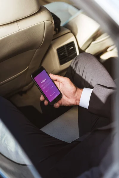 Περικομμένη Εικόνα Κρατώντας Smartphone Σελίδα Φορτώνεται Στο Instagram Αυτοκίνητο Επιχειρηματία — Φωτογραφία Αρχείου