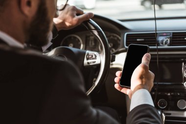 sürücünün sürüş araba ve holding smartphone takım elbiseli kırpılmış görüntü