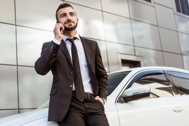 Smartphone ile konuşmak ve otomatik Caddesi üzerinde yakın duran yakışıklı işadamı