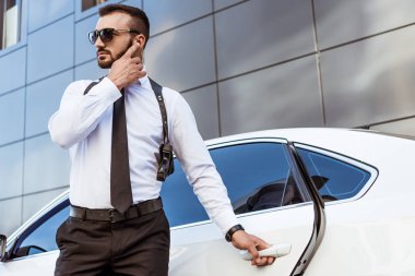 Yakışıklı güvenlik görevlisi dinleme ileti güvenlik kulaklık Caddesi ve açılış araba ile
