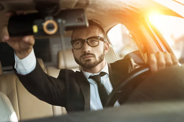 Conductor Guapo Traje Coche Conducción Espejo Fijación Durante Puesta Del —  Fotos de Stock