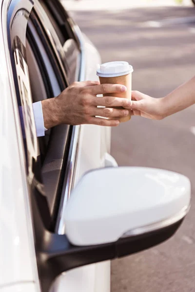紙コップのコーヒーを購入し 車に座っているドライバーの画像をトリミング — ストック写真