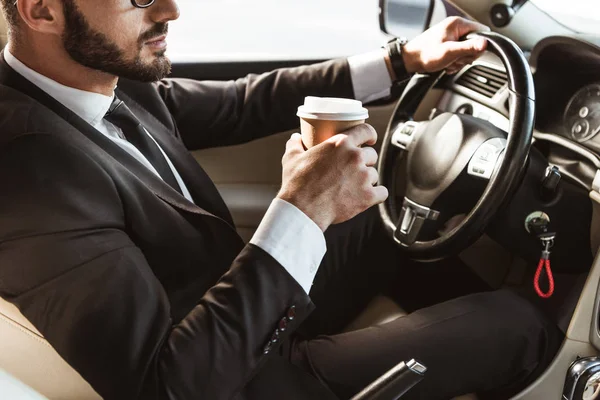 Przycięte Zdjęcie Kierowcy Garnitur Jazdy Samochodem Przytrzymując Kawy Papier Cup — Zdjęcie stockowe
