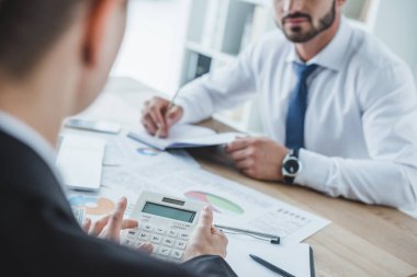 cropped image of financiers working at table in office clipart