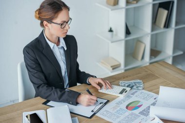 ofiste tabloda, hesap makinesi ve Pano çalışma yatırımcı yüksek açılı görünüş