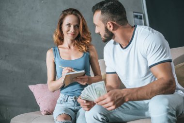 Aile bütçe planlama ve oturma odasında para sayma mutlu çift