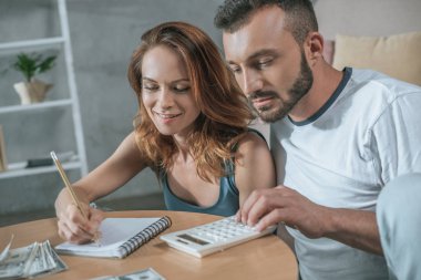 Çift defter ve oturma odasında hesap makinesi ile aile bütçe planlama