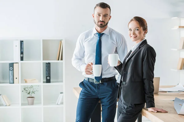 Contadores Alegres Sosteniendo Tazas Con Café Mirando Cámara Oficina — Foto de Stock