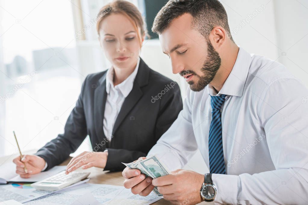 accountants counting dollar banknotes in office