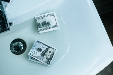 top view of us dollars in water in sink clipart