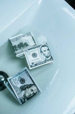 top view of dollar banknotes in water in sink clipart