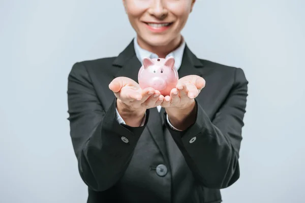 微笑金融家持有小猪银行灰色的裁剪图像 — 图库照片