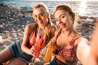 yaz içecekler içme ve kumlu plaj kameraya gülümseyen mutlu genç kız
