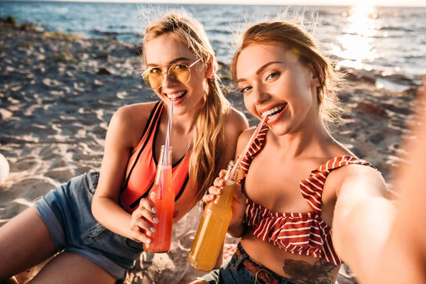 Happy Young Girlfriends Drinking Summer Beverages Smiling Camera Sandy Beach — Stock Photo, Image