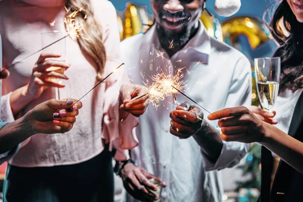 stock image cropped shot of multi ethnic friends celebrating new year with sparklers and champagne