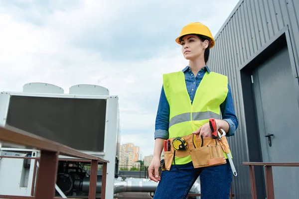 Kvinnlig Ingenjör Med Verktygsbälte Poserar Säkerhetsväst Och Hardhat — Stockfoto