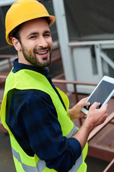neşeli yapı işçi Emanet yelek ve kask dijital tablet ile boş ekran kullanma