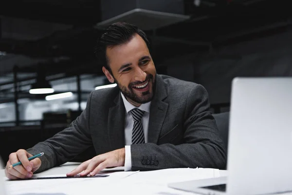 Lachen Mannelijke Ingenieur Werken Met Blauwdrukken Kijken Naar Laptop — Stockfoto