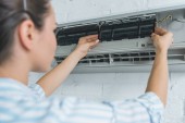 Selektiver Fokus von Arbeiterinnen, die Klimaanlagen reparieren
