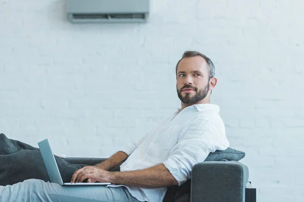 Bonito Barbudo Homem Usando Laptop Sofá Casa — Fotografia de Stock