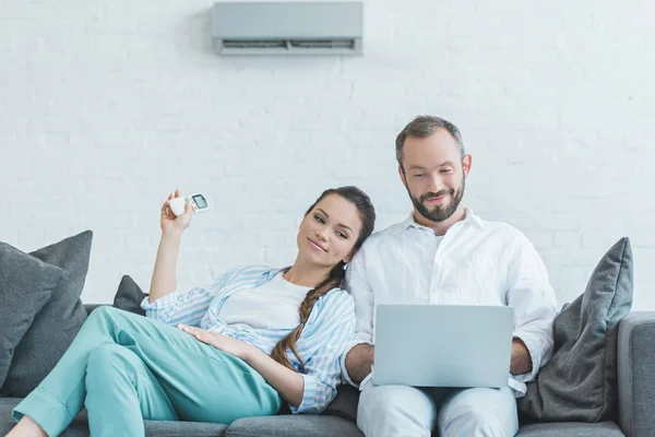 Couple Turning Air Conditioner Summer Heat While Using Laptop — Stock Photo, Image