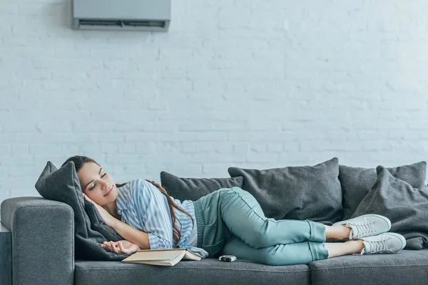 Kvinna Som Sover Soffan Med Boken Och Luftkonditioneringen Vägg — Stockfoto