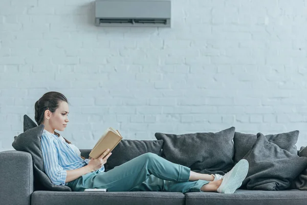 Woman Reading Book Sofa Air Conditioner Wall Home — Stock Photo, Image