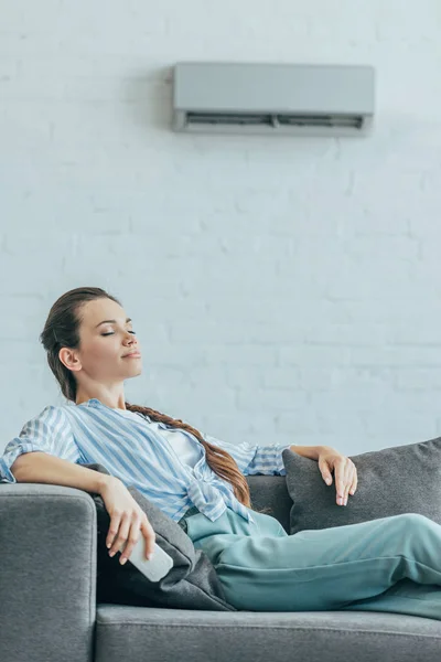 Donna Appoggiata Sul Divano Con Climatizzatore Parete Concetto Calore Estivo — Foto Stock