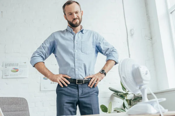 Confused Sweaty Businessman Looking Electric Fan Office — Stock Photo, Image
