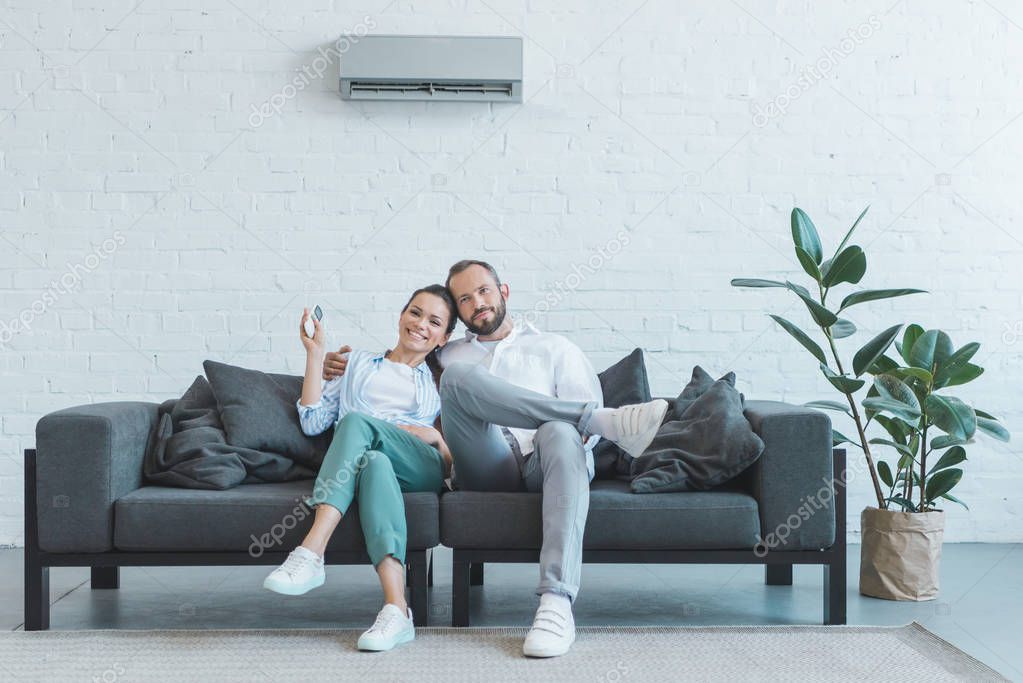 couple turning on air conditioner during the summer heat at home  