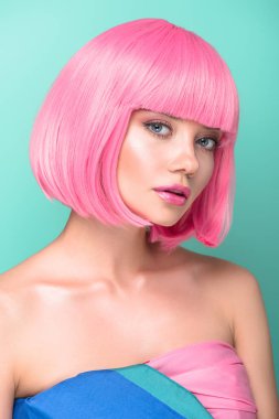 Turkuaz üzerinde izole kamera bakarak pembe bob olan baştan çıkarıcı kadın kesmek