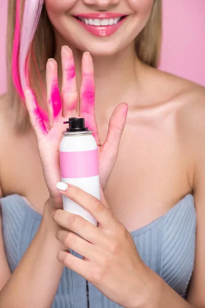 拍摄的微笑年轻女子手持喷漆的头发在手前覆盖粉红色的油漆隔离粉红色 — 免费的图库照片