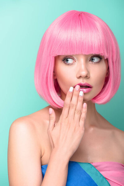 shocked young woman with pink bob cut covering mouth with hand isolated on turquoise