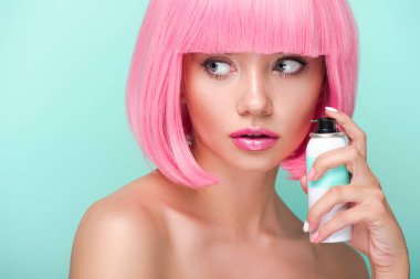 attractive young woman with pink bob cut holding coloring hair spray isolated on turquoise clipart