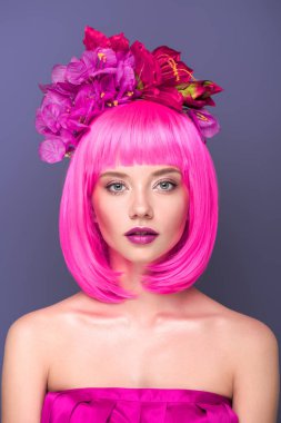 güzel genç kadının pembe bob kesim ve çiçeklerle violet izole kamera bakarak saç yakın çekim portre