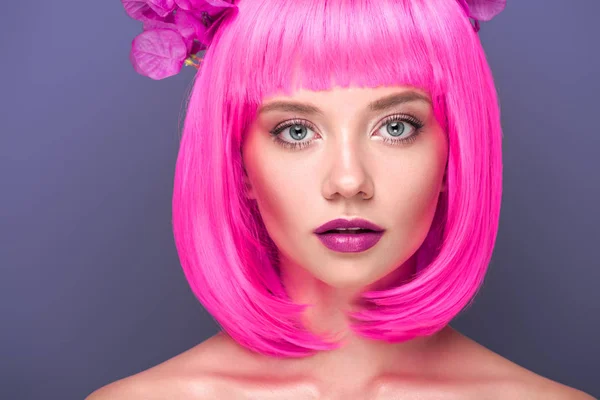 特写肖像的迷人的年轻女子粉红色的鲍勃切割和花的头发看着在紫色的相机隔离 — 图库照片