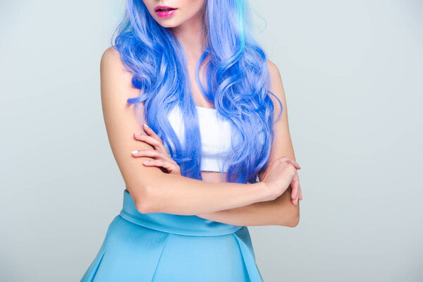 cropped shot of young woman with bright blue hair isolated on grey