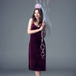Glückliche zukünftige Braut in Schleier für Junggesellenabschied hält Haufen pinkfarbener Luftballons auf grau