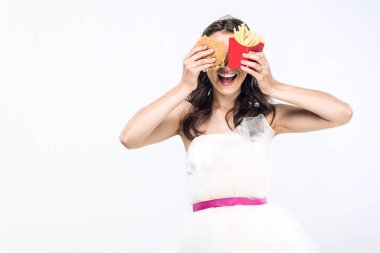 Genç gelin gelinlik hamburger ve patates kızartması üzerine beyaz izole gözlerle kapsayan