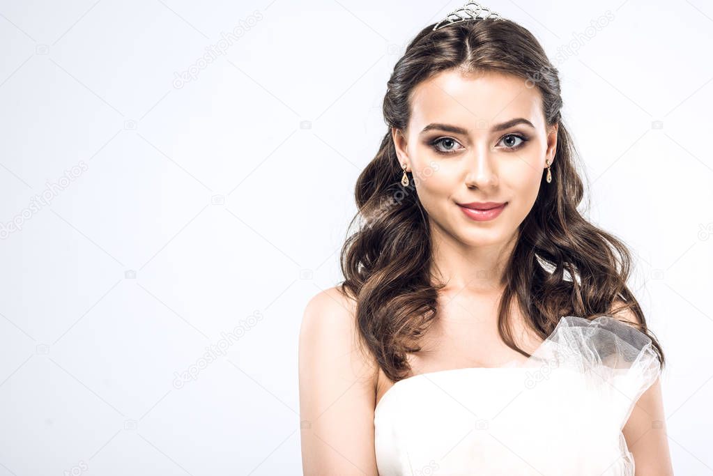 close-up portrait of young bride in wedding dress with earrings and tiara isolated on white