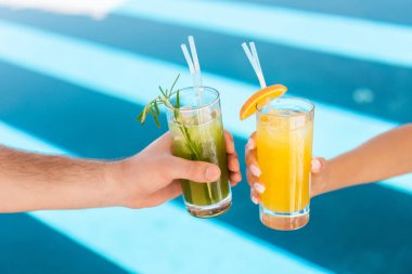 çift gözlük taze limonata ile yüzme havuzunda tutan görünümünü kırpılmış