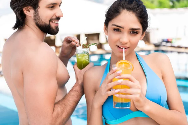 Junges Paar Trinkt Frische Cocktails Der Nähe Von Schwimmbad — kostenloses Stockfoto
