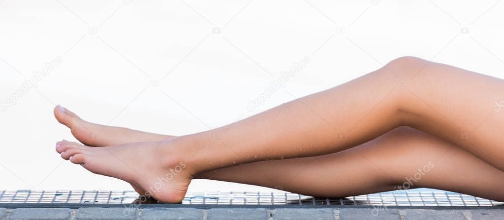 partial view of tanned female legs having sunbath