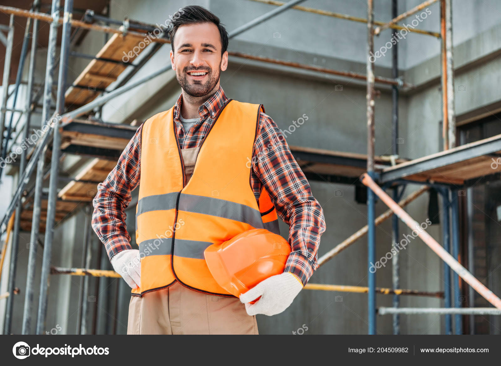 Glücklicher Bauarbeiter Reflektierender Weste Mit Helm Während Vor Dem Haus  - Stockfotografie: lizenzfreie Fotos © AllaSerebrina 204509982