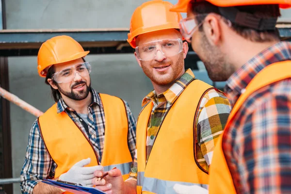 Grupo Constructores Sombreros Duros Chalecos Reflectantes Discutiendo Trabajo — Foto de stock gratis