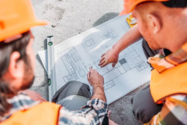 Hoge Hoekmening Van Bouwers Wijzend Blauwdruk — Stockfoto