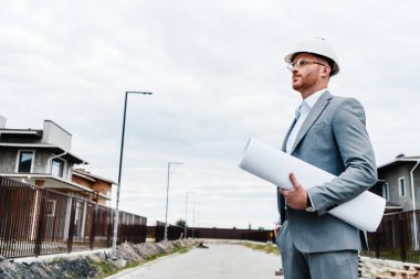 takım elbise ve ev inşa seyir planı tutan baret yakışıklı mimar