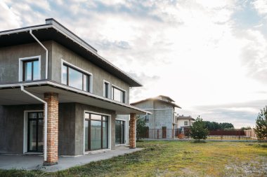 row of modern concrete buildings under cloudy sky clipart