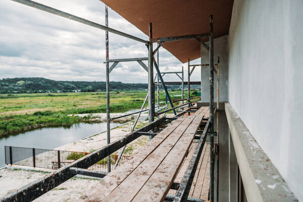 scaffolding of construction site of modern building near river